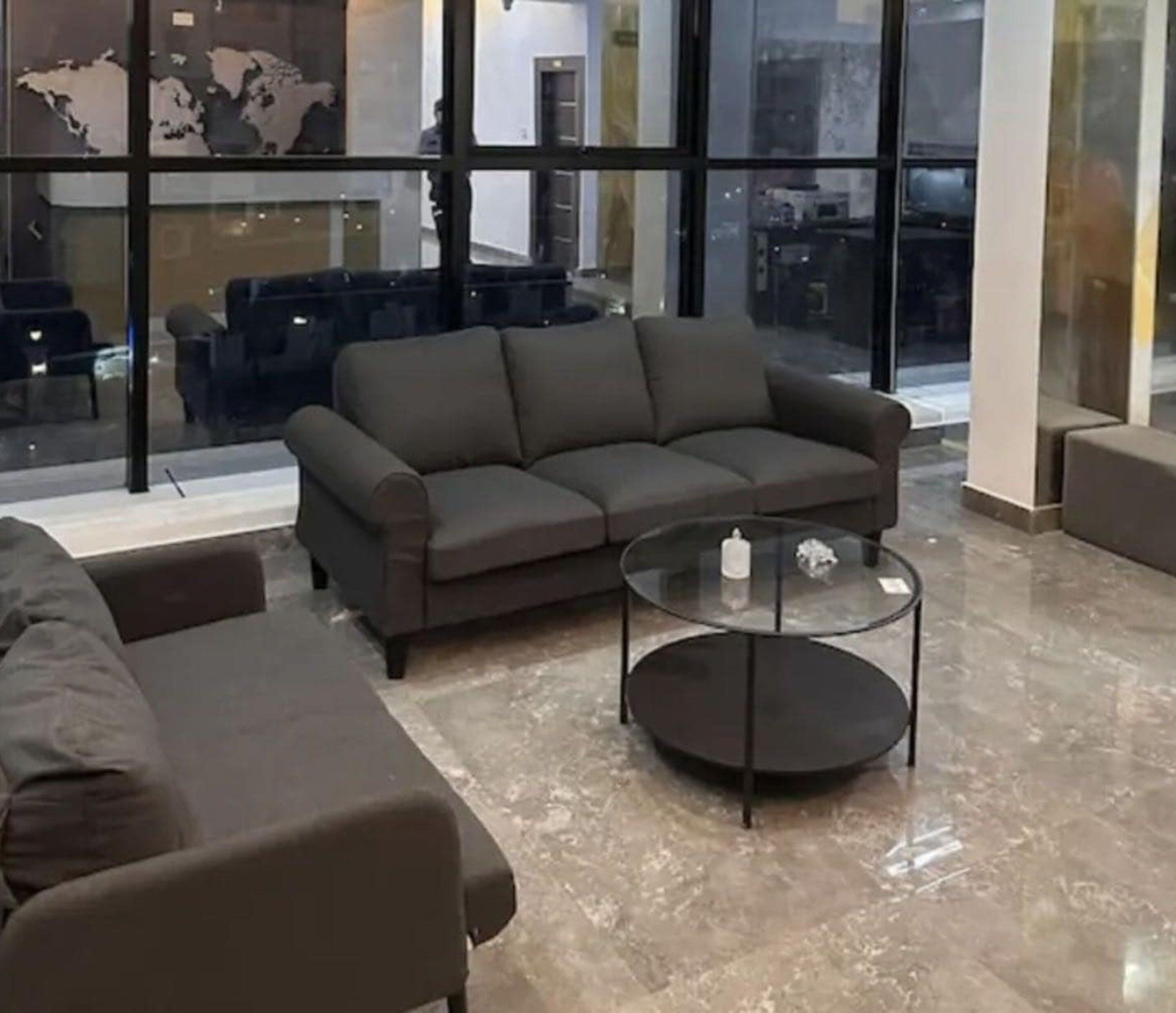 Una sala moderna con un sofá y una mesa de centro de vidrio.