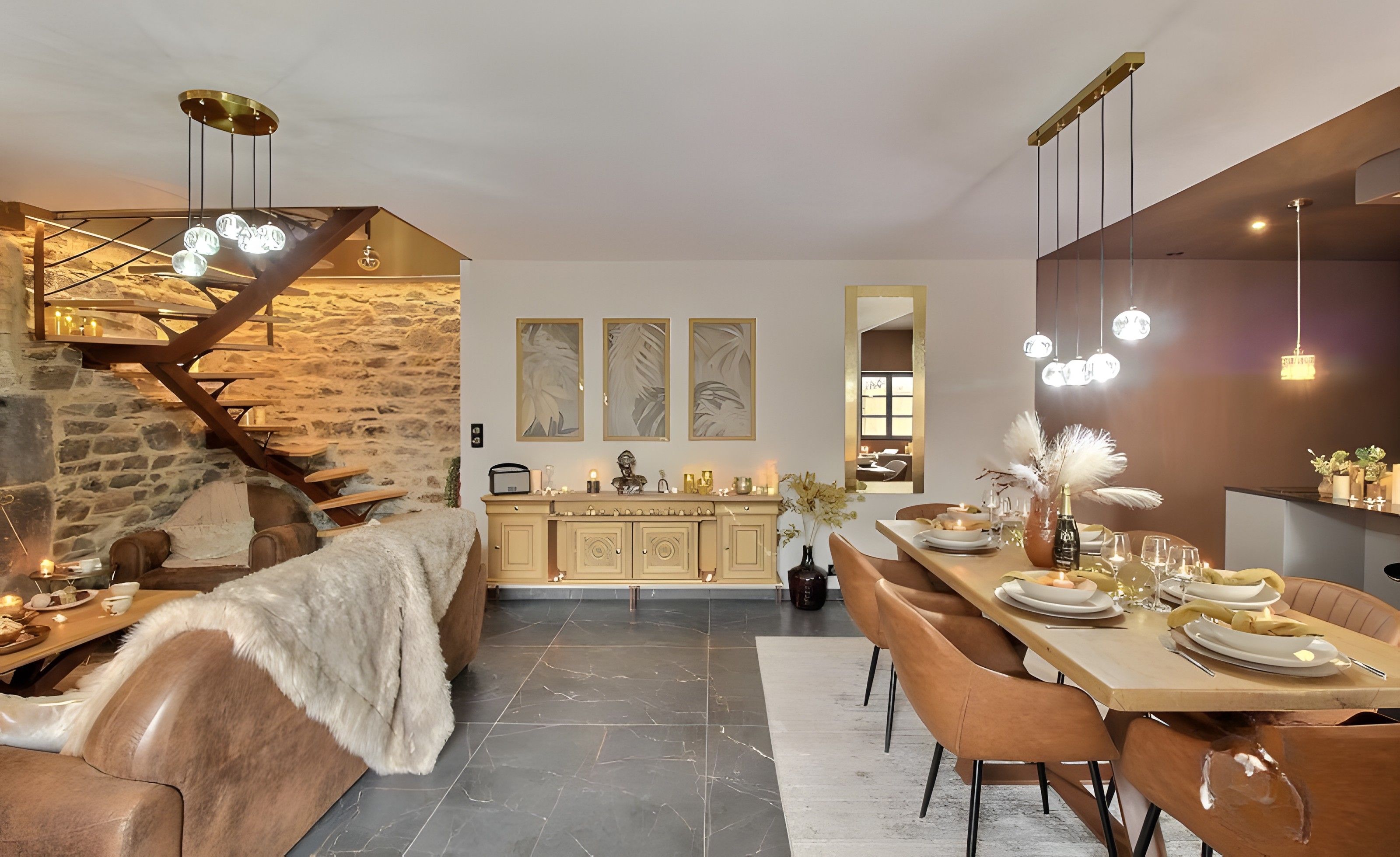 Un espace repas moderne avec un mur en pierre, un escalier en bois et une table à manger dressée pour quatre personnes.