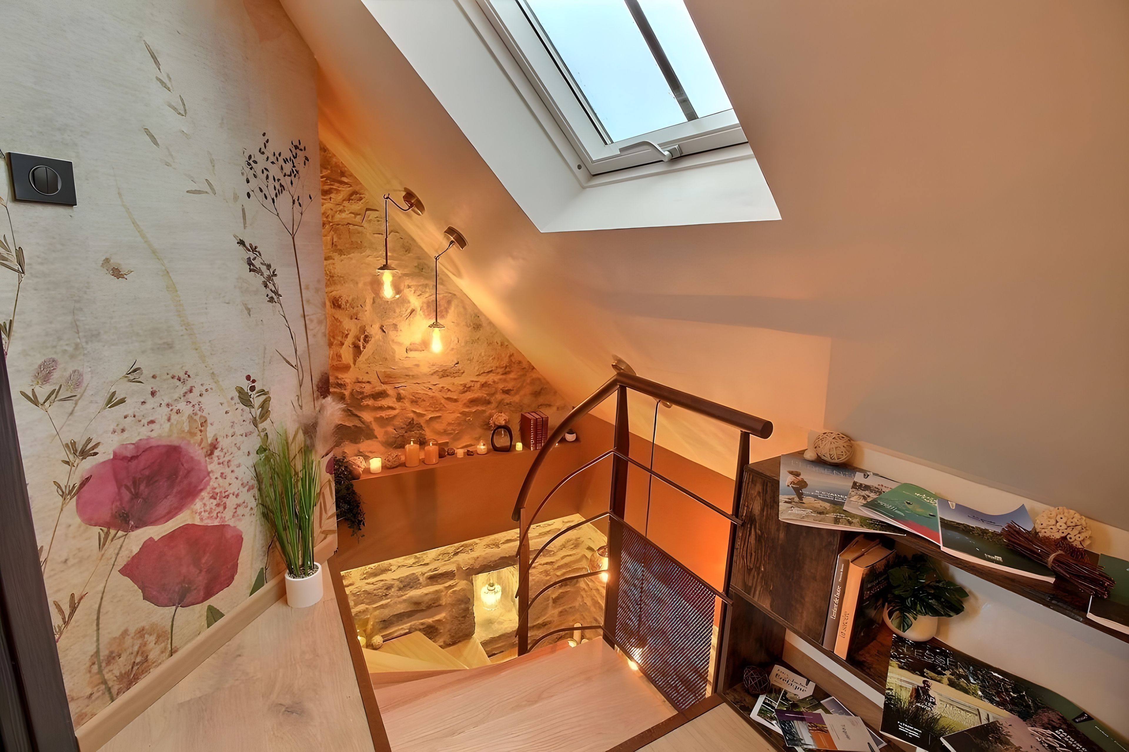 Un escalier avec un mur en pierre et une lucarne.