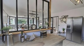 A modern kitchen with a large mirror, stainless steel appliances, and a view of the outdoors.