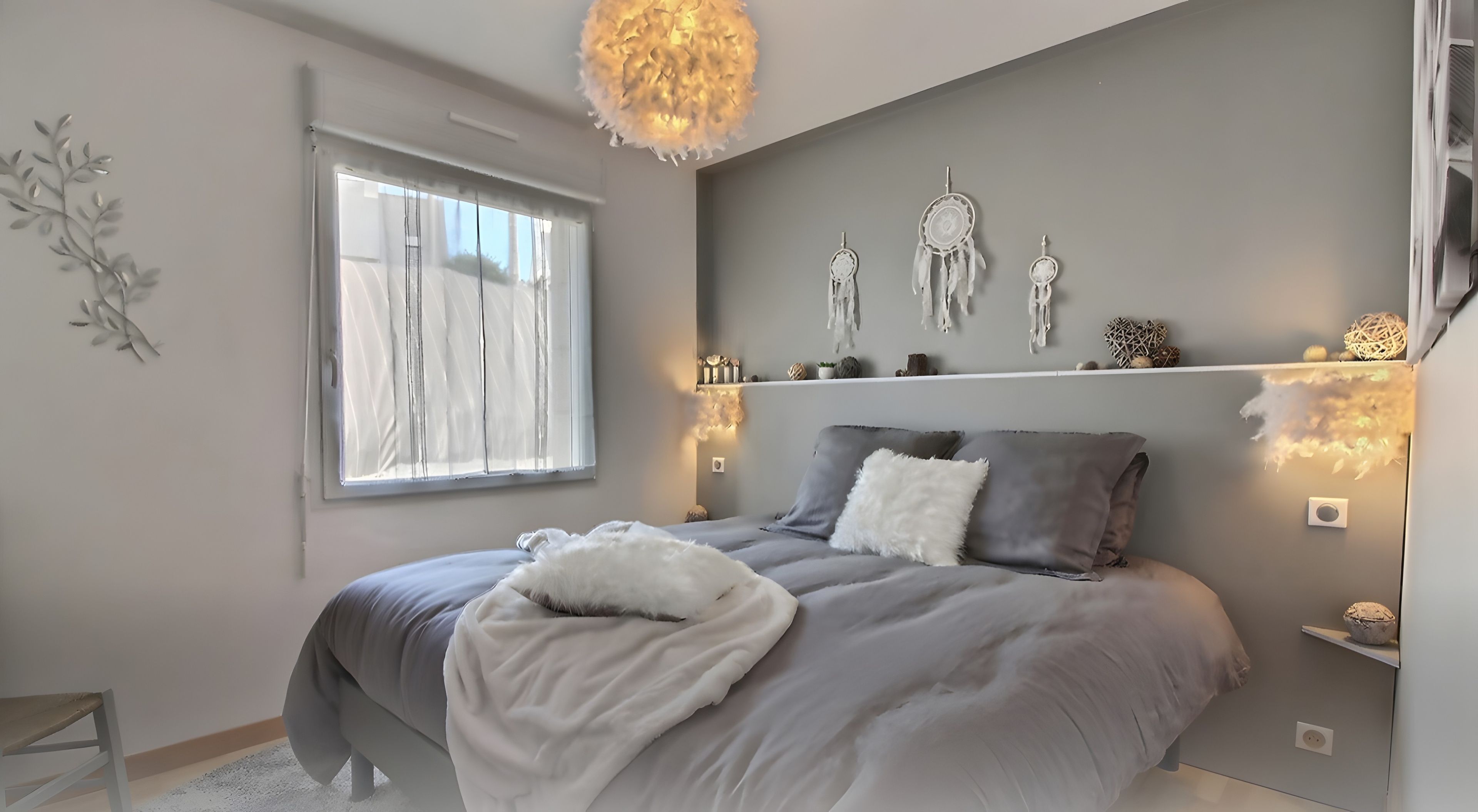 Una camera da letto con un letto, comodini, una finestra e decorazioni alle pareti.