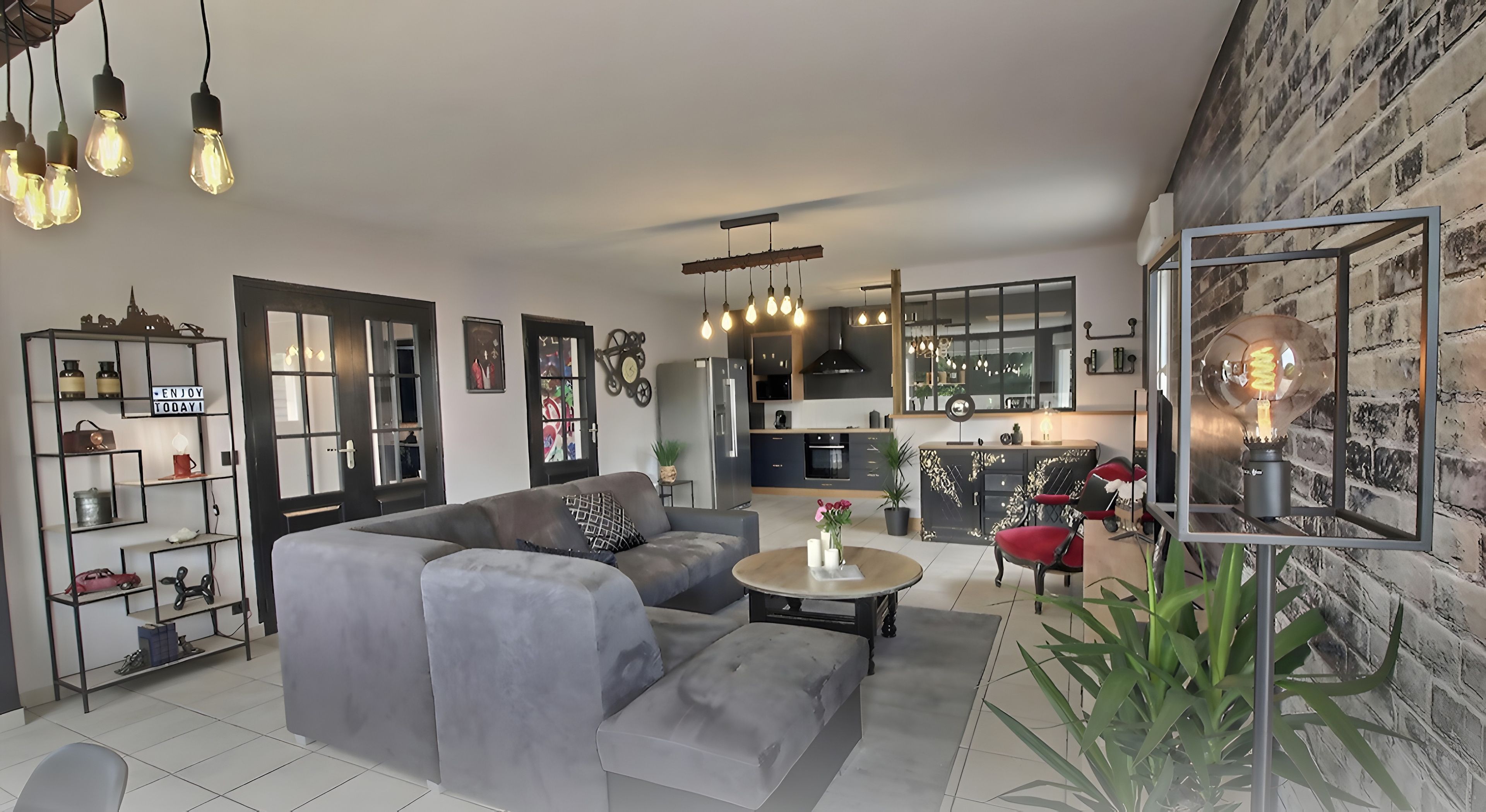Ein modernes Wohnzimmer mit einer Eckcouch, einem Couchtisch und einem Essbereich mit einer Küche im Hintergrund.