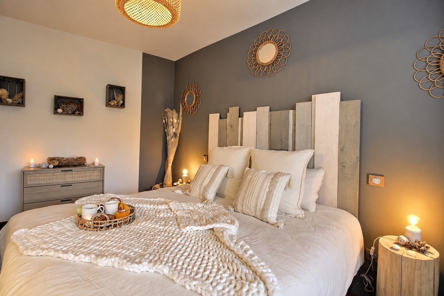 A bedroom with a large bed, bedside tables, wall decor, and a bedside lamp.