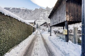 Eine verschneite Straße führt zu einem Gebäude mit einem Holzdach und einem Metallvorsprung.