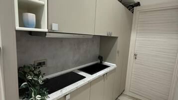 A narrow kitchen with a countertop, cabinets, and a sink.