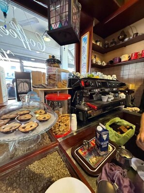 A bakery counter with various baked goods, a coffee machine, and a display case with pastries. - B&B Kapo Azzurro Monterotondo (Monterotondo)