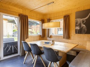 A wooden interior with a dining table, chairs, and a bench. - One-bedroom Cabin (Sankt Georgen am Kreischberg)
