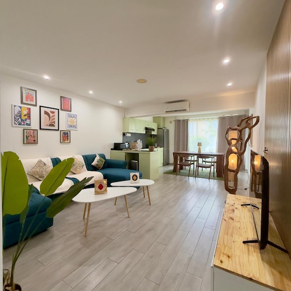 A modern living room with a sofa, coffee table, and artwork on the wall.