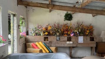 Una habitación con bañera de hidromasaje, vigas de madera y una pared decorada con flores.