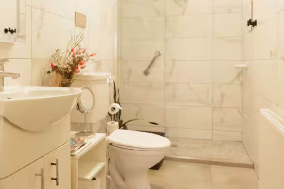 A bathroom with a sink, toilet, and shower.