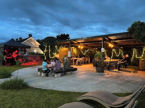 Un espace extérieur aménagé en terrasse, avec des sièges et une scène pour des concerts.