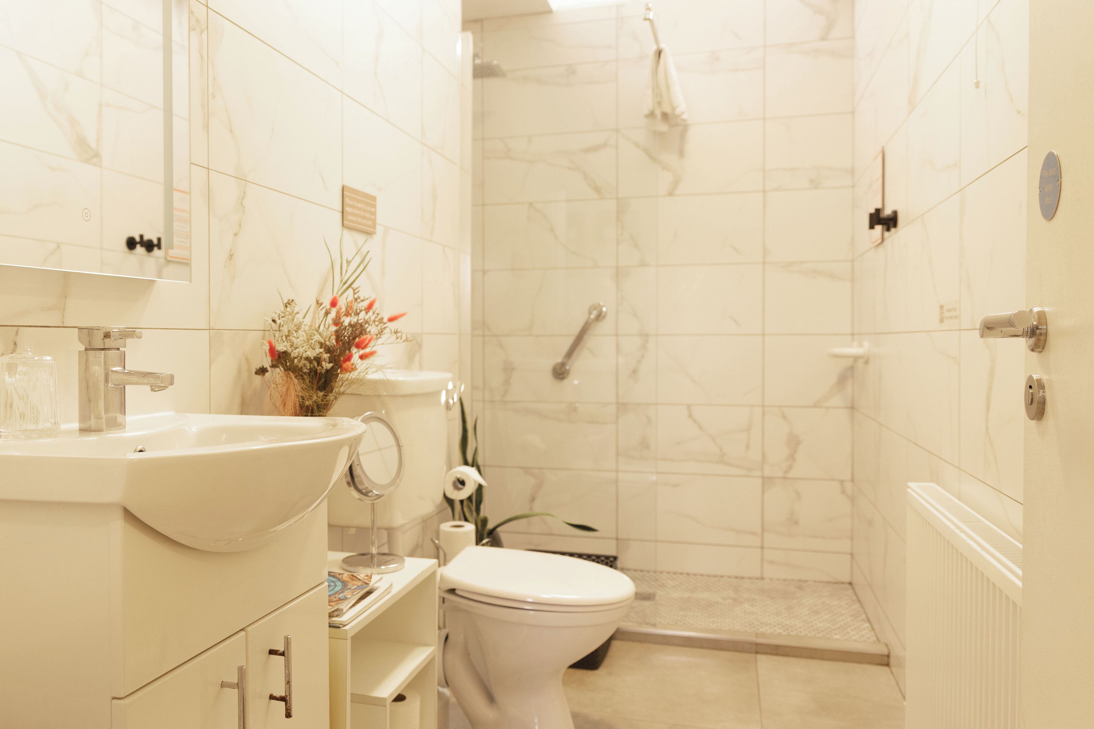 A bathroom with a sink, toilet, and shower.
