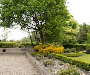 Un jardin bien entretenu, avec une grande variété de plantes et un chemin pavé de pierres.