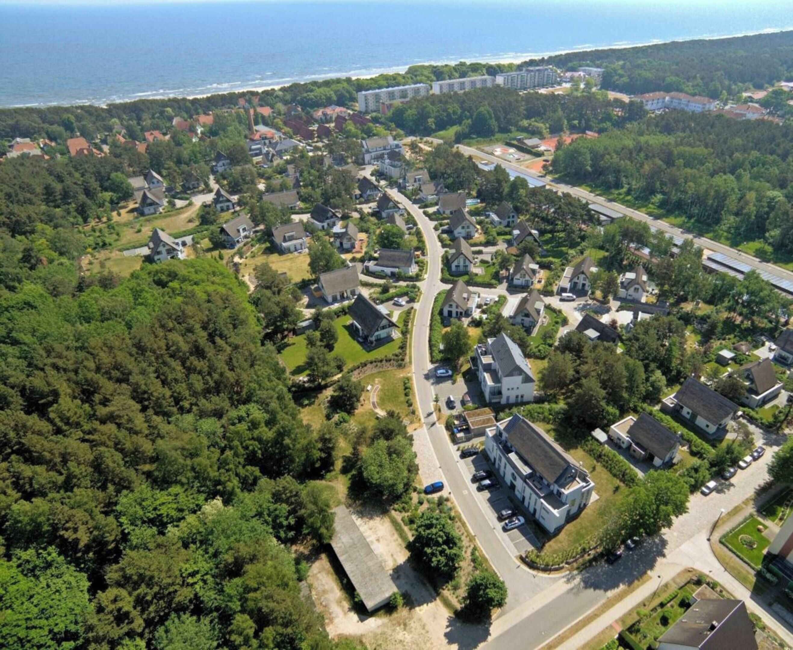 A residential area with houses, roads, and a coastline.