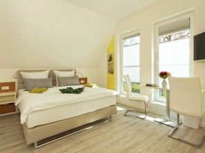 A modern bedroom with a bed, bedside tables, a desk with a chair, and a window with blinds. - Holiday Home in Karlshagen With Sauna (Karlshagen)