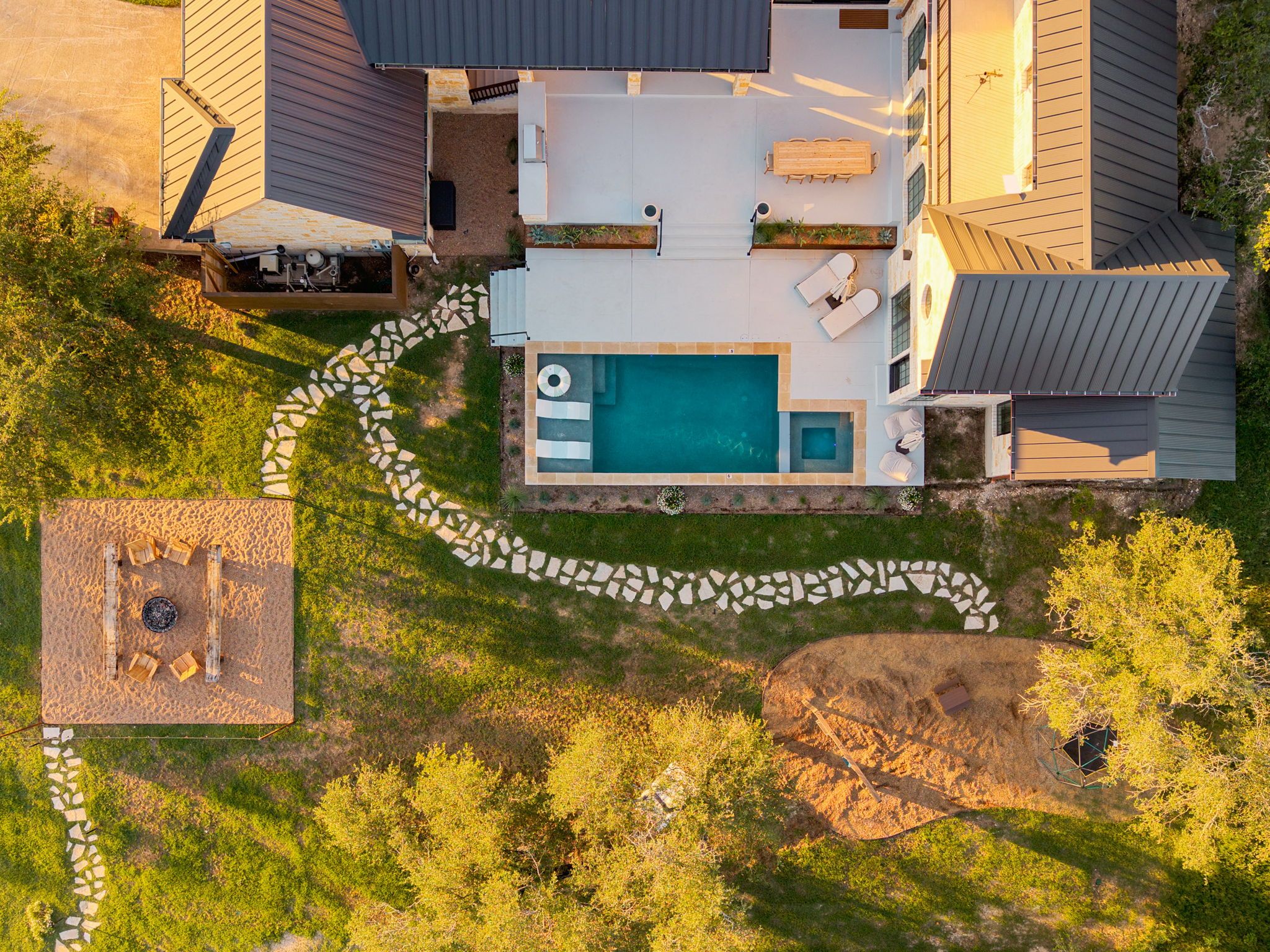 Propiedad residencial con piscina, mobiliario de exterior y sendero de piedra.