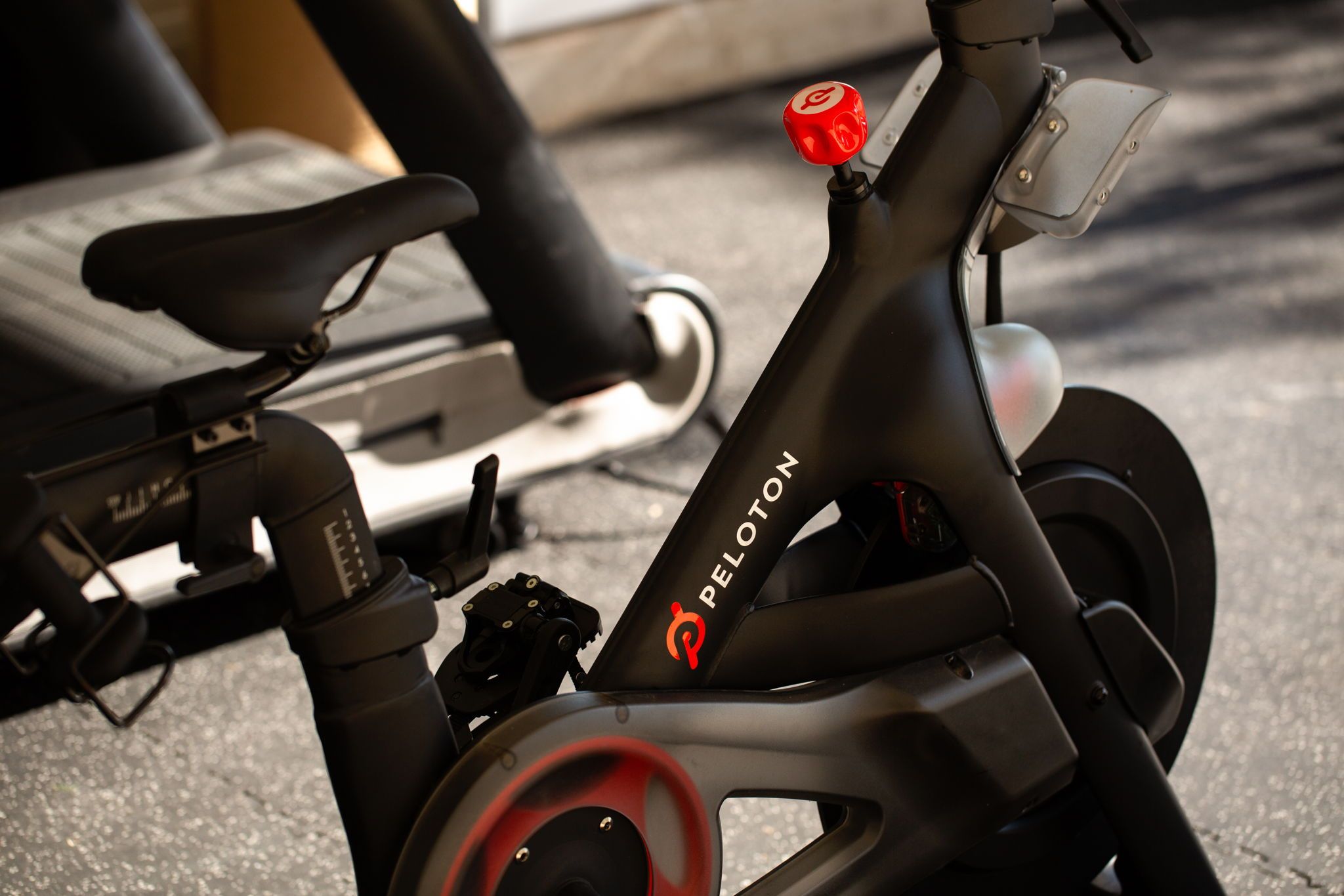 Una bicicleta estática con una palanca roja y el nombre de la marca 'PELOTON' en el marco.