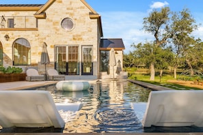 A stone house with a swimming pool, outdoor seating, and a pergola. - Deep Eddy Ranch (Dripping Springs)