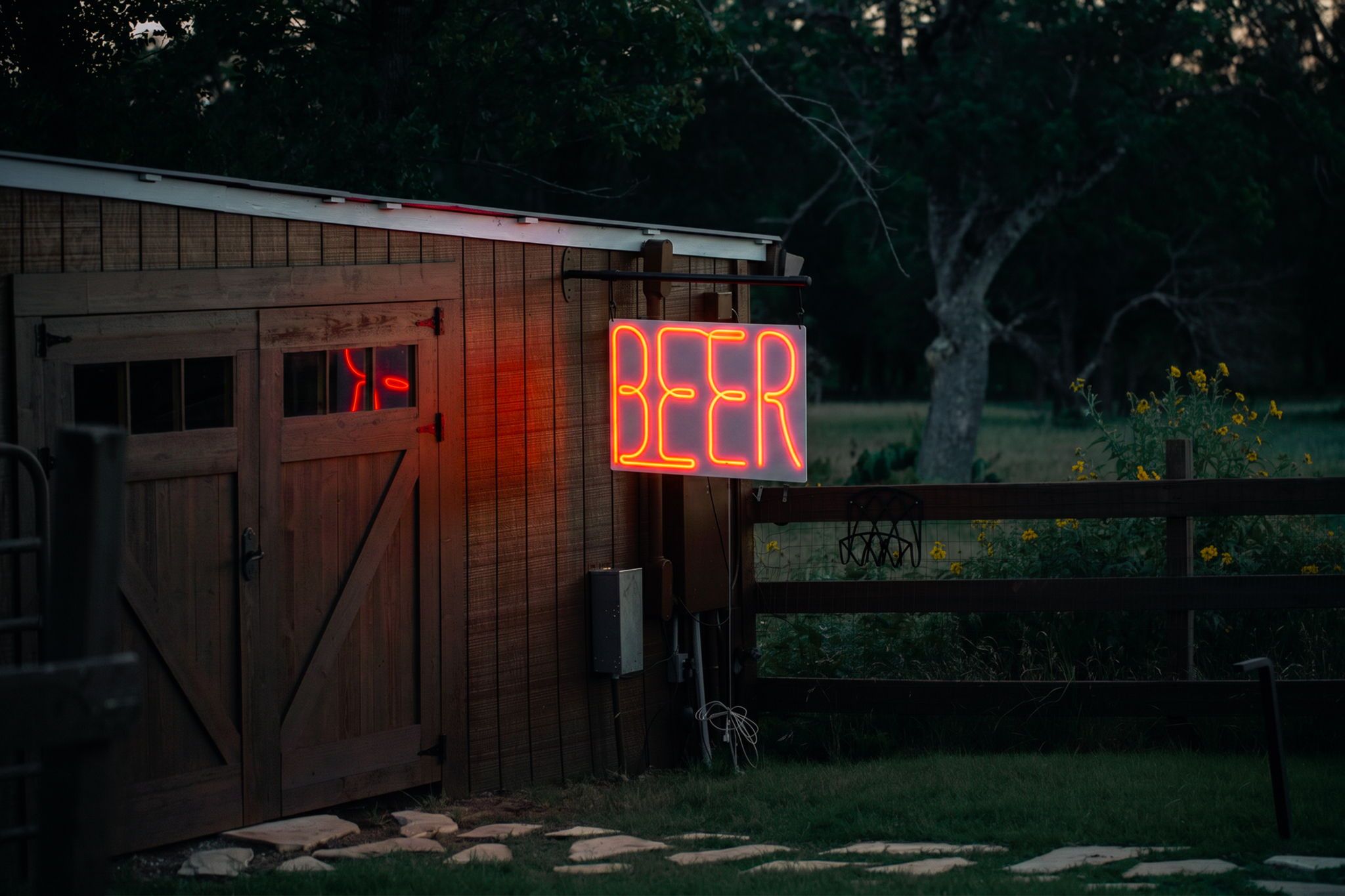 Un edificio de madera con un letrero de neón que dice 'BEER' y una valla de madera.