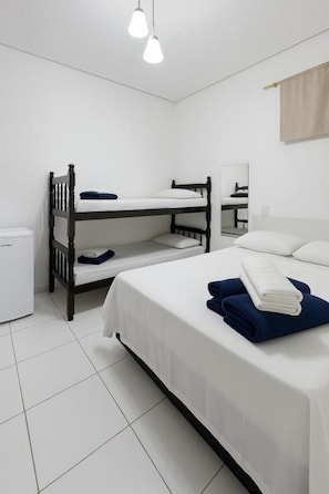 A room with bunk beds, a small desk, a mirror, and a white tiled floor. - Pousada Luz do Sol  (Penha)
