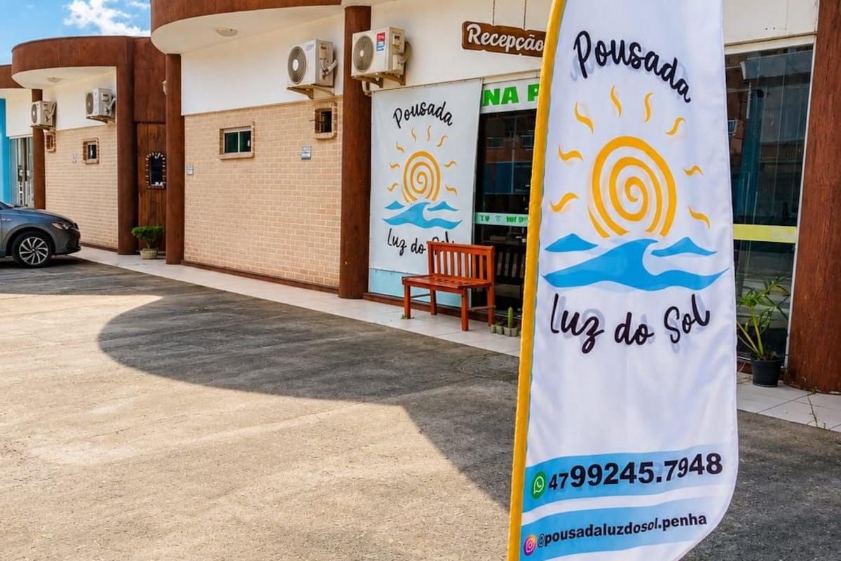 A building with a reception area, a flag with a sun and waves design, and a contact number.
