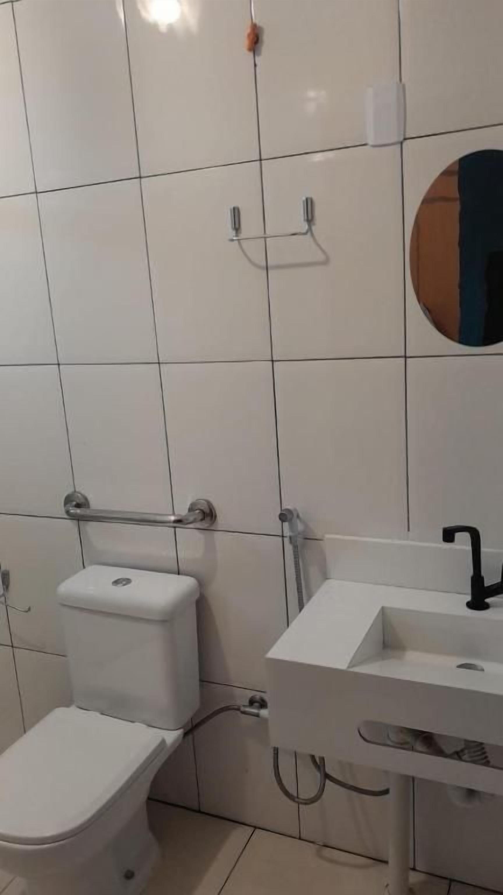 Un baño con inodoro, lavamanos y espejo.