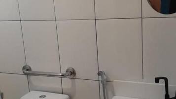 Un baño con inodoro, lavamanos y espejo.