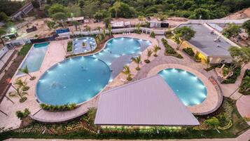A large outdoor swimming pool complex with multiple interconnected pools and a surrounding landscaped area.