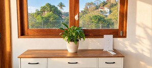 A wooden desk with a potted plant and a remote control. - Jungle Bliss Villa | Large Private Pool, Ocean Glimpses & Sunsets (Sayulita)