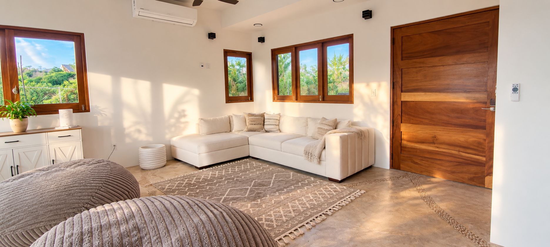 A modern living room with a sectional sofa, a patterned rug, and a wooden door.