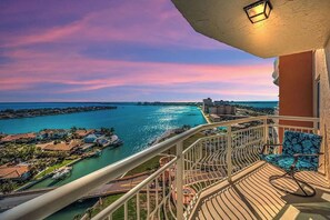 Ein Balkon mit Blick auf einen Yachthafen und einen Sonnenuntergang über dem Wasser.
