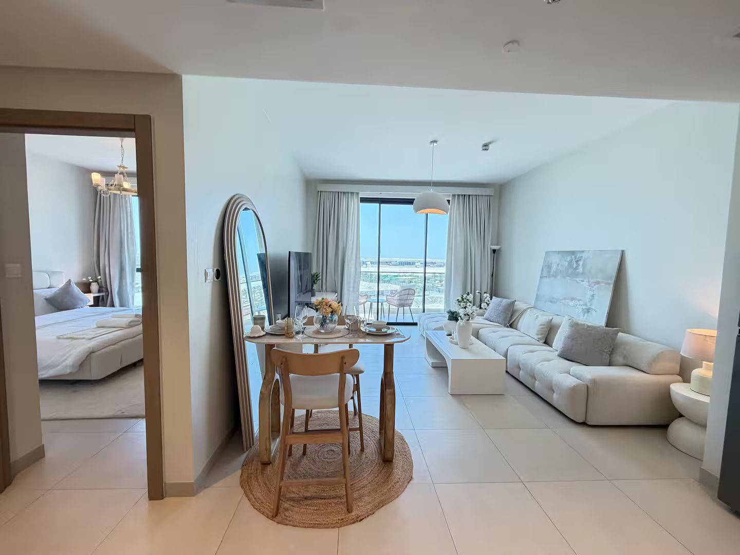 Ein modernes Hotelzimmer mit Balkon, Essbereich und Wohnbereich.