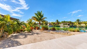 Ein Resort mit Pool, Palmen und einer Sandstrandanlage.