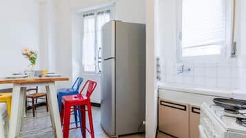 Pieni, käytännöllinen keittiö, jossa on jääkaappi, liesi ja ikkuna.