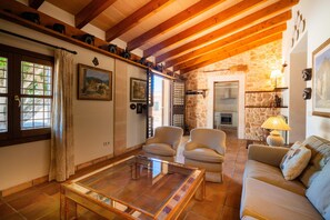 A cozy living room with a fireplace, a coffee table, and a sofa. - Rapalin, Villa 5StarsHome Mallorca (Arta)