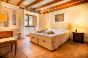 A bedroom with a large bed, two bedside lamps, a wooden dresser, a chair, and a window with curtains. - Rapalin, Villa 5StarsHome Mallorca (Arta)