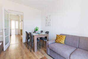 Ein modernes Wohnzimmer mit Essbereich, einer Couch und einem Gemälde an der Wand.