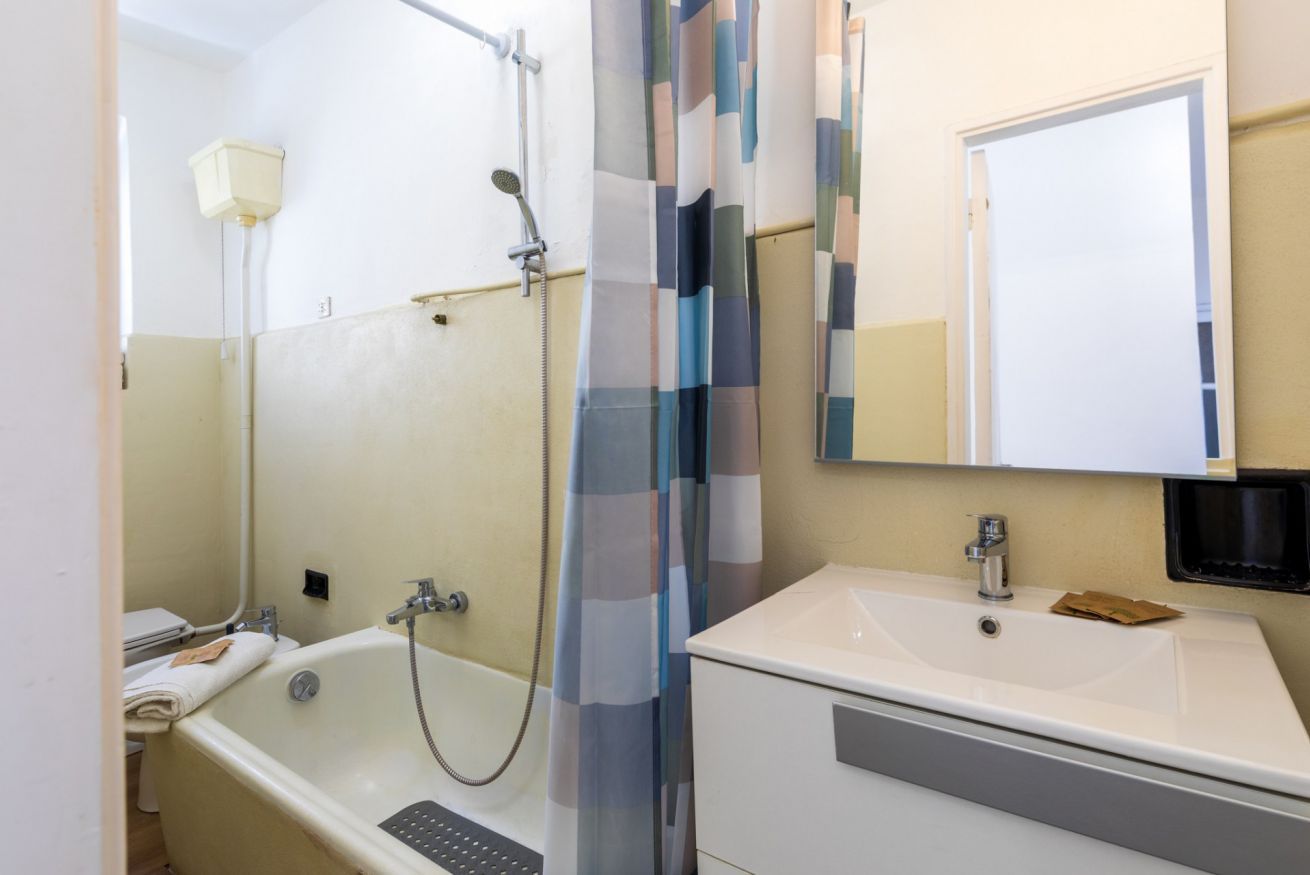 Ein Badezimmer mit Badewanne, Waschbecken, Spiegel und Duschvorhang.