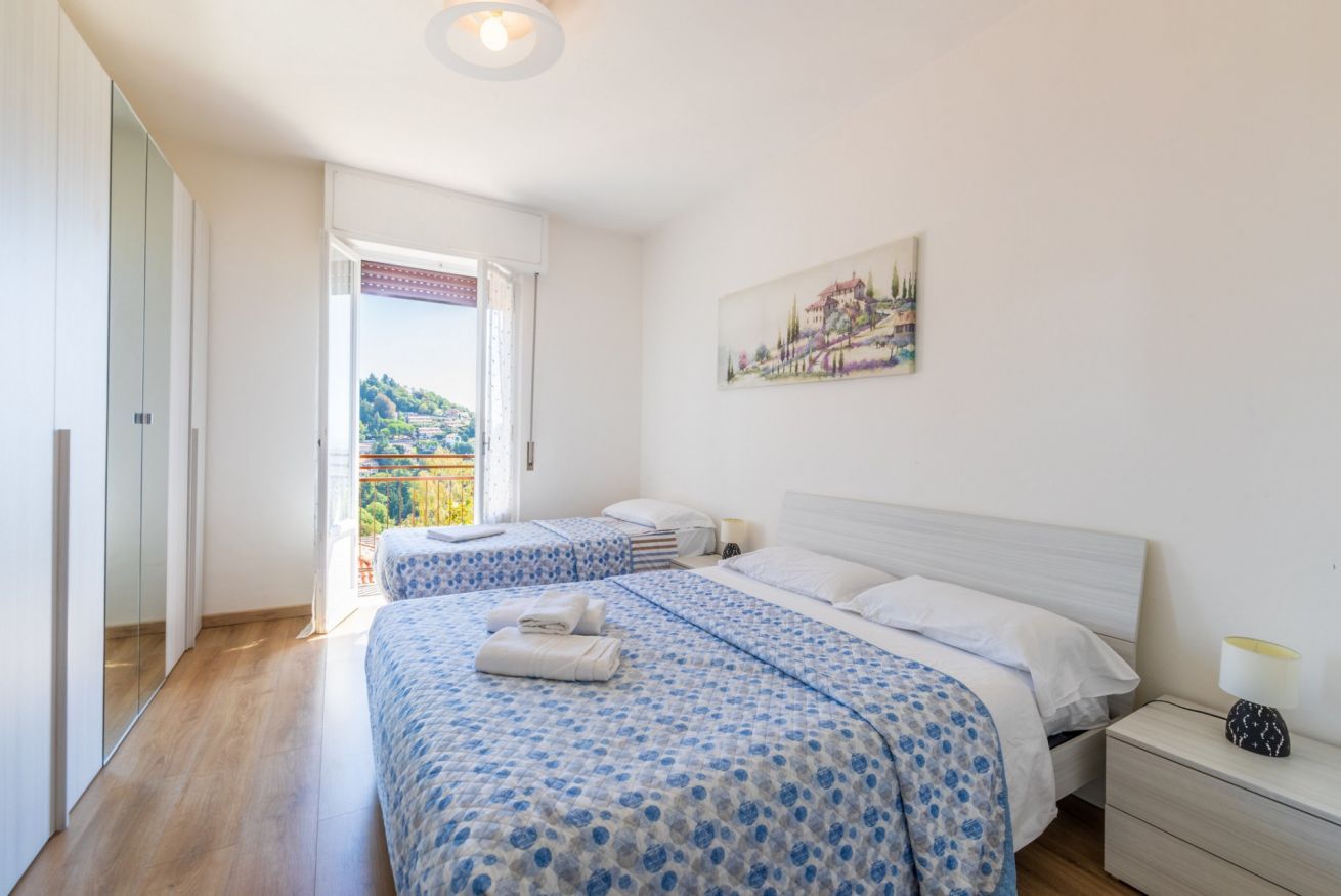 Ein Schlafzimmer mit zwei Betten, einem Bild an der Wand und einem Fenster mit Blick.