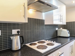 A modern kitchen with a gas stove, kettle, and toaster on the counter. - 2B Granville Road (Colchester)