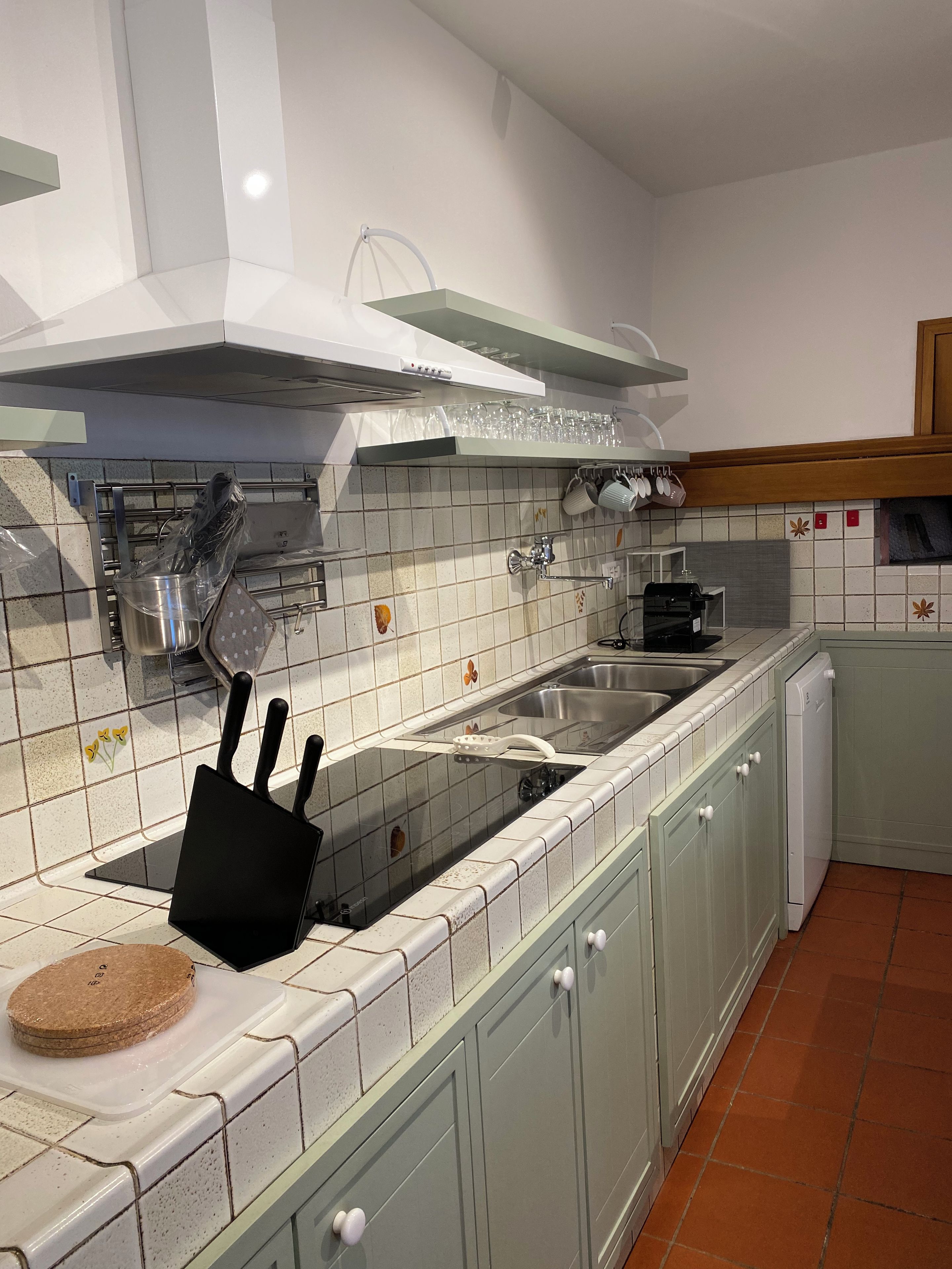 A kitchen with a stove, sink, and cabinets.