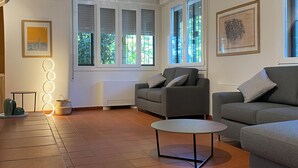 A spacious living room with two grey sofas, a round coffee table, and a large window with blinds. - Villanova 4 rooms (Villanova)