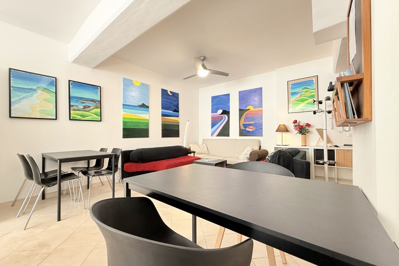 Un espacio habitable moderno con comedor, sofá y obras de arte en las paredes.