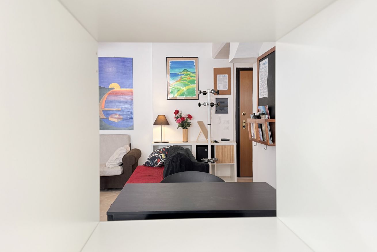 Une pièce de taille modeste comprenant un lit, un bureau, une chaise, une bibliothèque et une porte.
