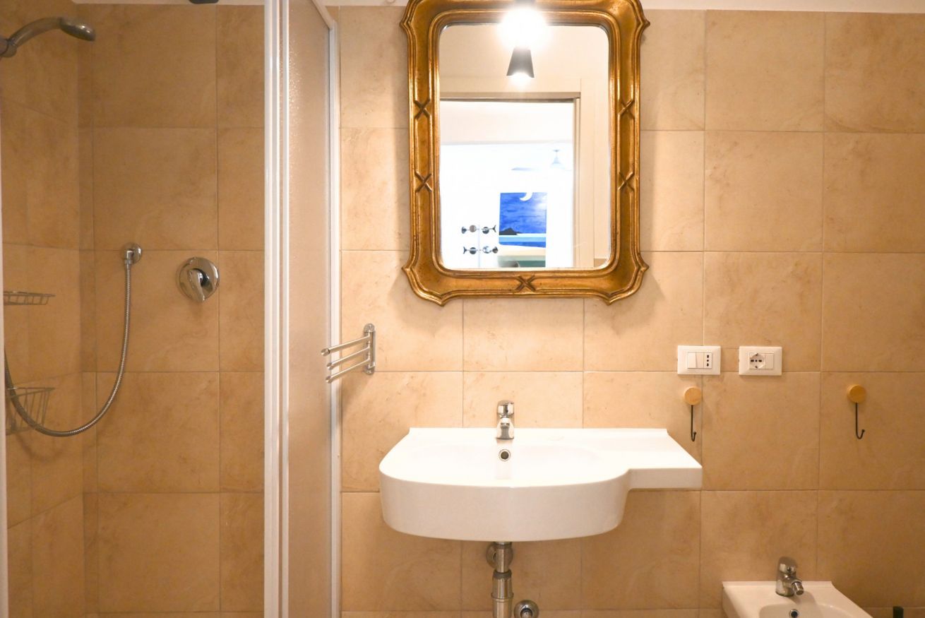 A bathroom with a shower, sink, and mirror.