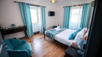 Ein Schlafzimmer mit einem Bett, einem Schreibtisch, einem Stuhl und einem Fernseher.