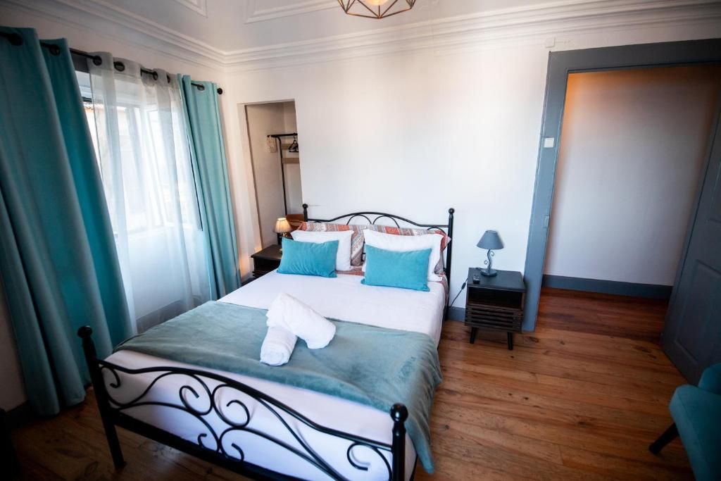 Une chambre à coucher bien rangée, avec un lit, des tables de chevet et une petite table de nuit.