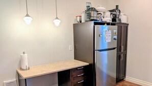 A compact kitchen with a built-in refrigerator, a countertop with a paper towel dispenser, and a small bench. - Comfortable private room near downtown Victoria (Victoria)
