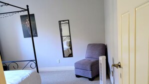A bedroom with a four-poster bed, a chair, a standing heater, and a mirror on the wall. - Comfortable private room near downtown Victoria (Victoria)