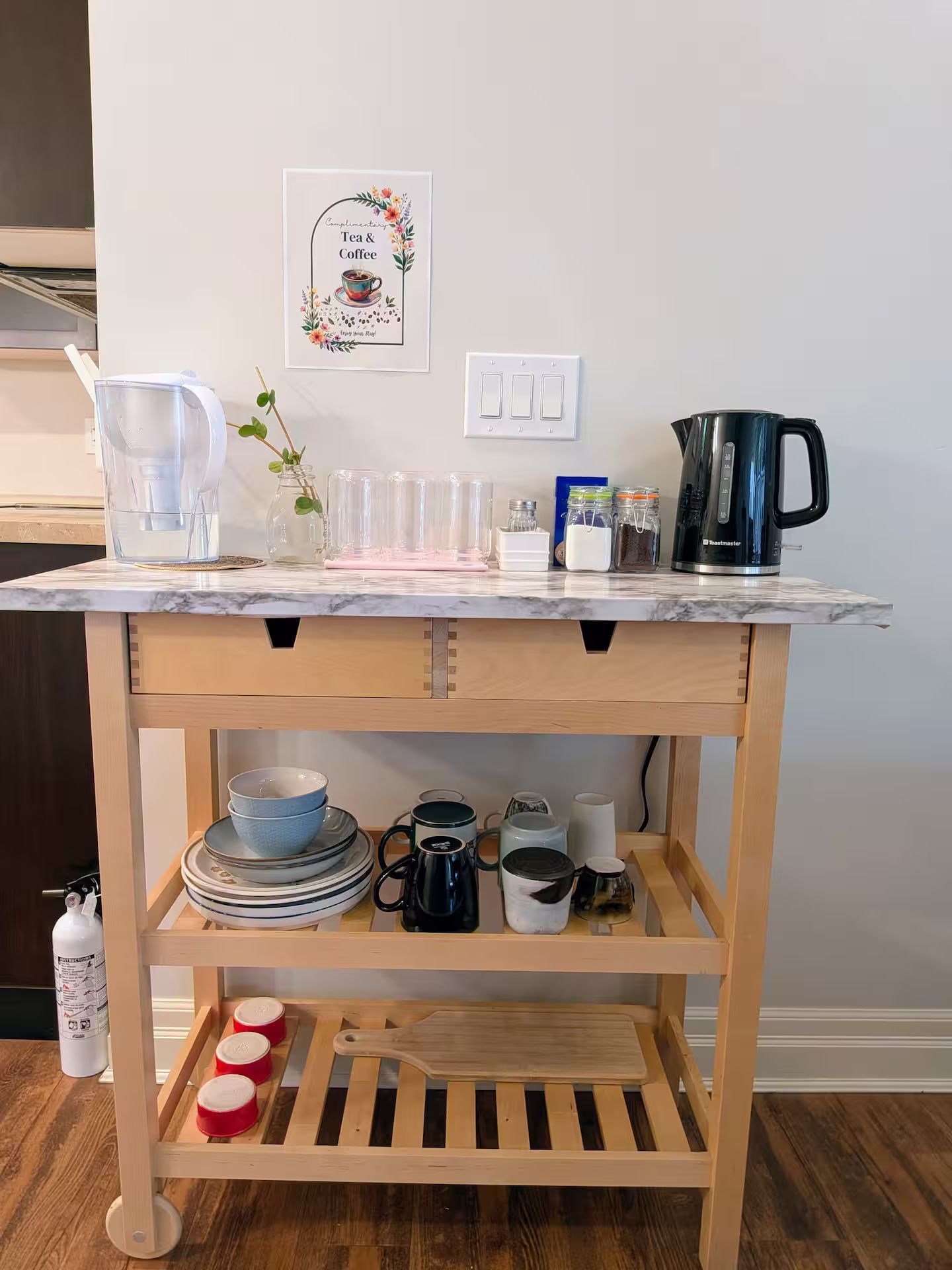Un piano di lavoro in cucina con una moka, una brocca d'acqua e diversi oggetti da cucina.